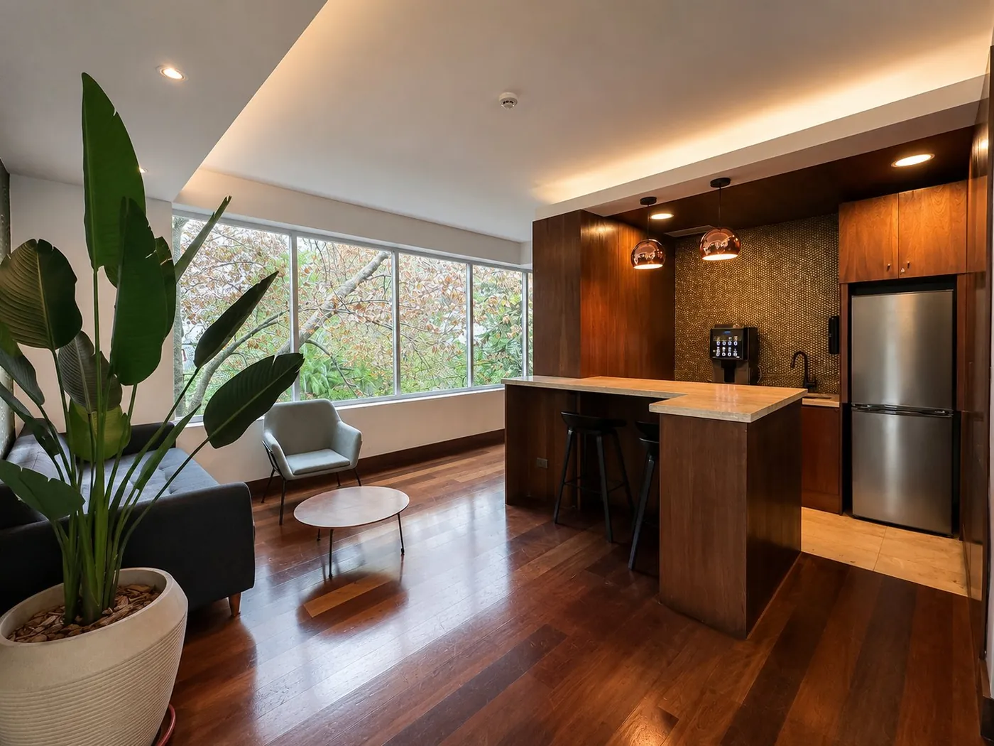 Kitchenette con barra, terminaciones en madera y vista al entorno verde