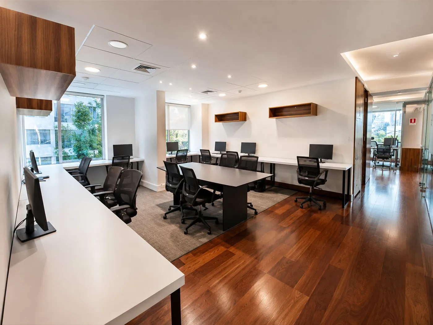 Planta abierta con puestos de trabajo y mesa central